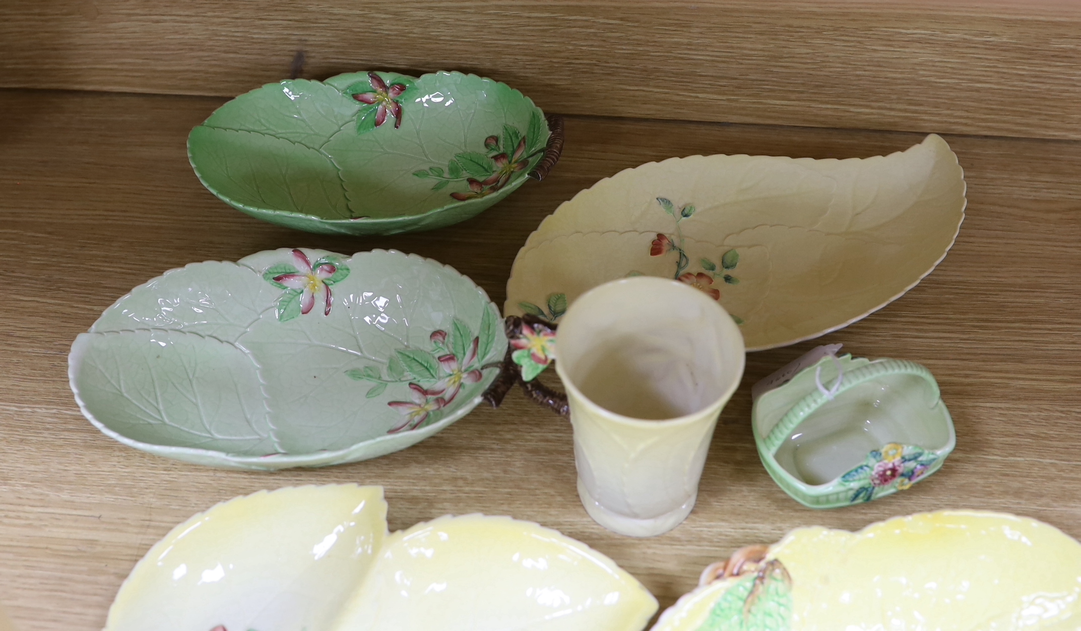 A collection of Carlton Ware leaf moulded dishes, a cup and a preserve pot and cover